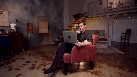 hombre trabajando en una computadora portátil en un acogedor apartamento de loft