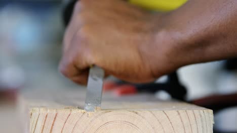Carpenter carving wood with hammer at table 4k