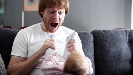 Funny-dad-grimacing-and-playing-with-baby-daughter