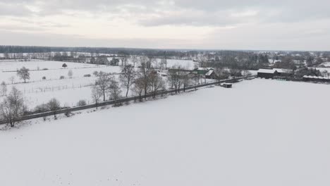 aerial view of a snowy farm with horses in northern germany