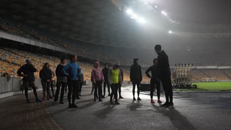 group of runners pre-workout in a stadium