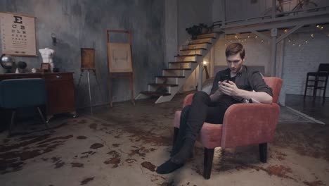 man using smartphone in a stylish loft apartment