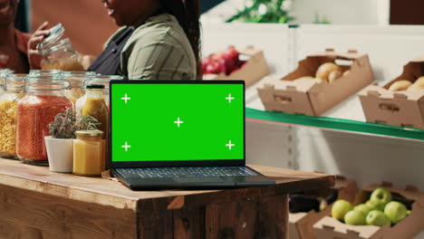 portátil con pantalla verde en funcionamiento en una tienda de comestibles local