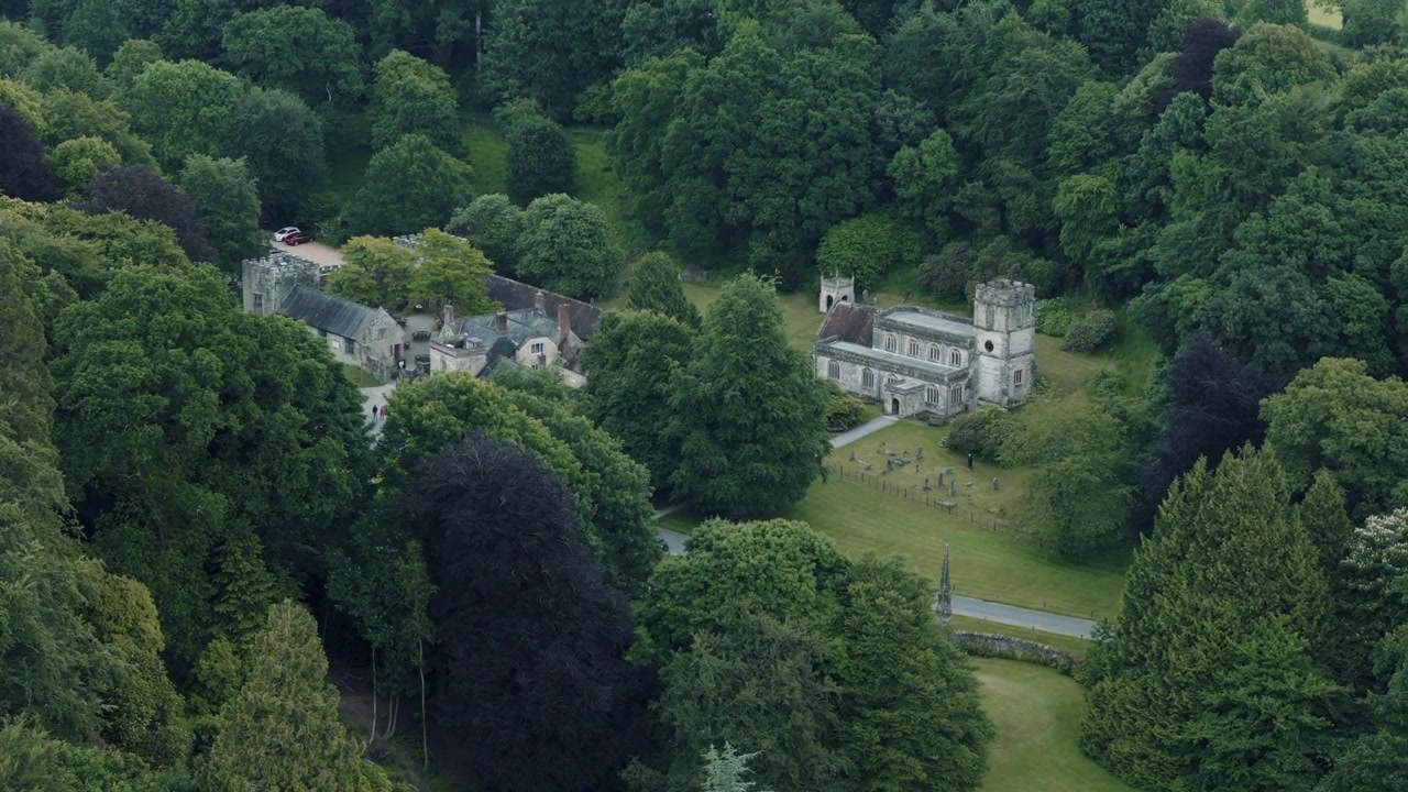 Vista aerea circolare dello Spread Eagle Inn circondato da giardini lussureggianti a Stourhead, Inghilterra.