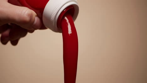 hand pouring ketchup from a bottle