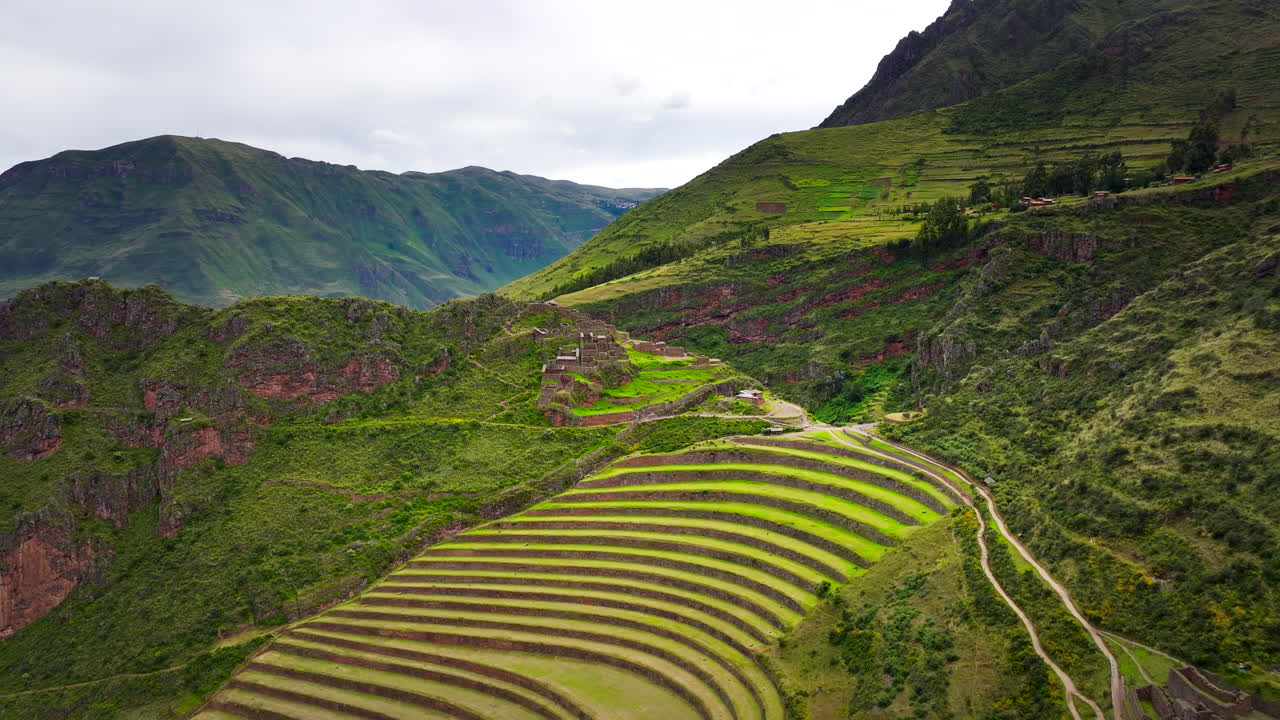 Veduta aerea delle terrazze Inca e delle rovine in pietra nel sito archeologico di Pisac nella Valle Sacra, Perù, con ripresa aerea all'indietro.