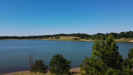 pushing forward with drone to over the water at a man-made lake