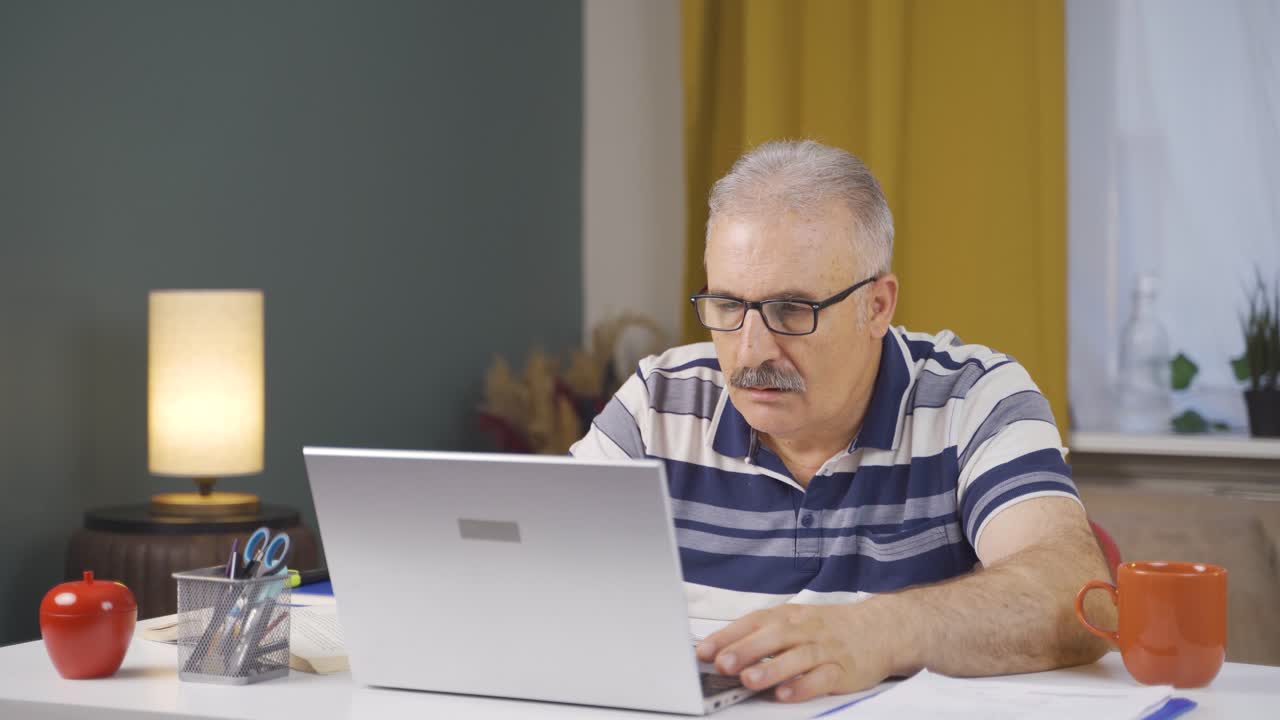 Home office worker old man reading bad news and feeling frustrated.