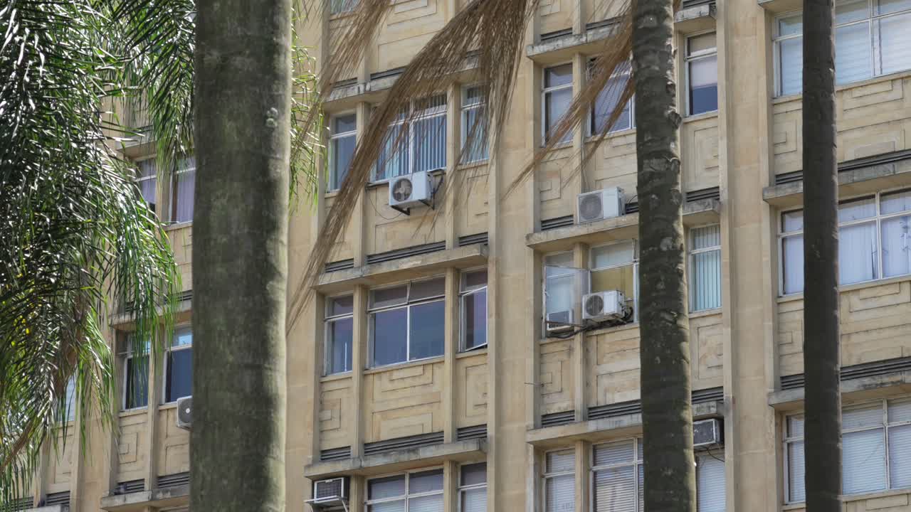 Real estate building facade with modern air conditioning unit near palm tree hot climate