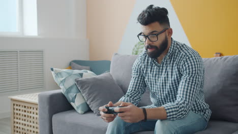 man playing video games on a couch