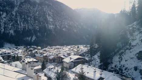 A-panoramic-aerial-winter-scene-of-snow-covered-mountains-in-nature's-breathtaking-beauty-in-Pozza-di-Fassa,-Italy