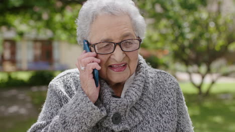 Retrato-De-Una-Anciana-Mujer-De-Raza-Mixta-Hablando-Por-Teléfono-Disfrutando-Charlando-En-El-Soleado-Jardín