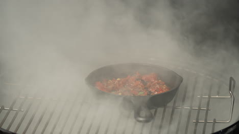 macro of smoking dish on a skillet using a smoker grill