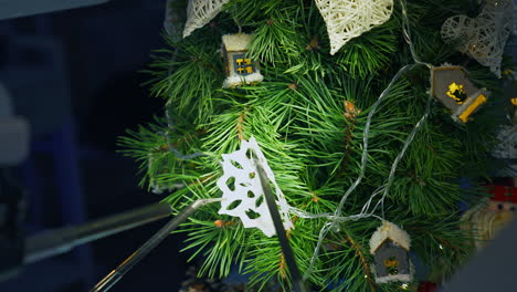 christmas tree and metal cyborg arms. robotic equipment for decorating new year tree with paper snowflake. intelligent machinery.