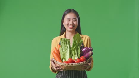 woman holding a basket of fresh vegetables