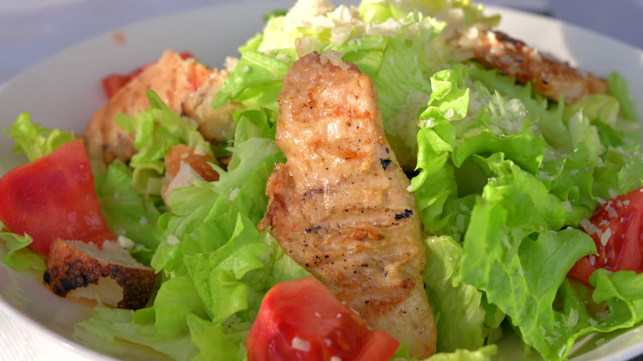 Primo piano di un'insalata Caesar in un piatto bianco