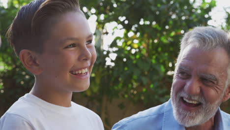 male multi-generation hispanic family relaxing in garden at home together