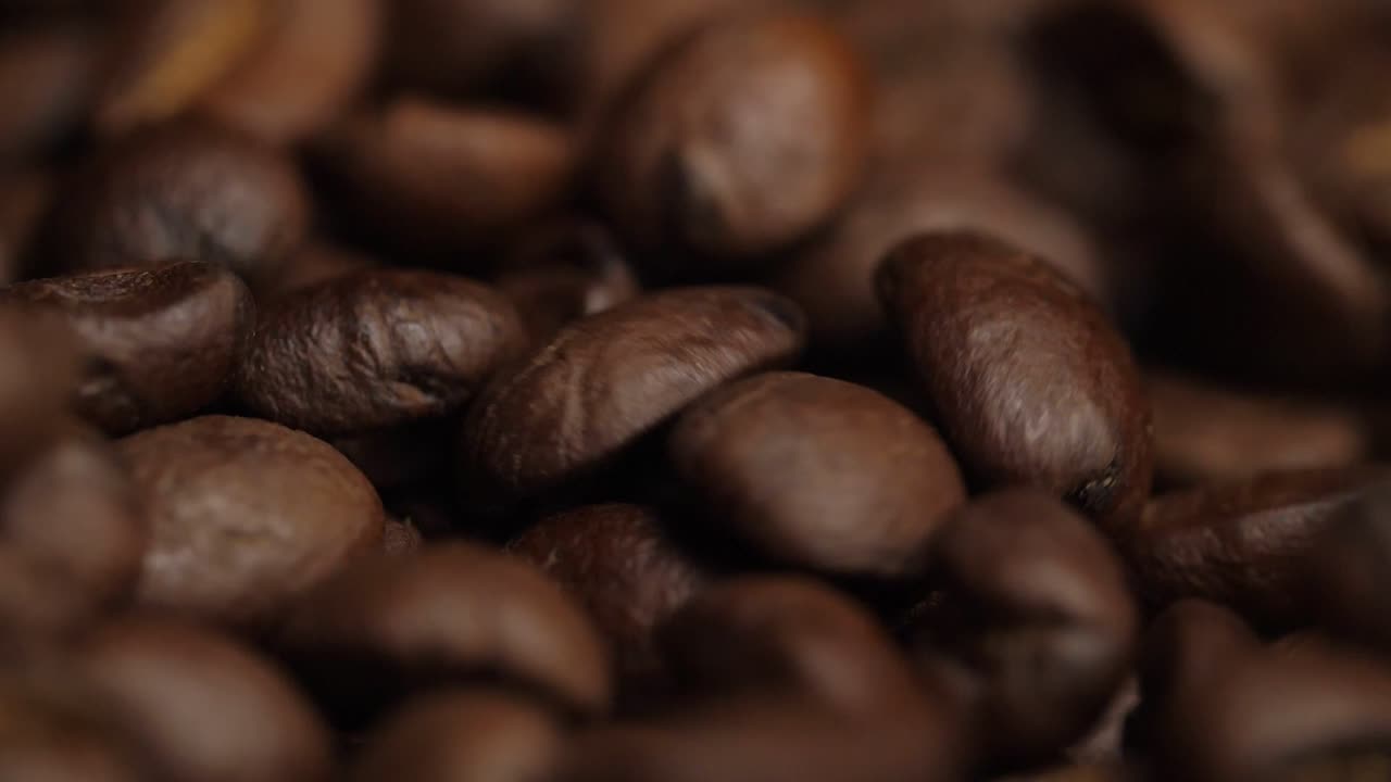 Primo piano: chicchi di caffè tostati che cadono, rallentatore