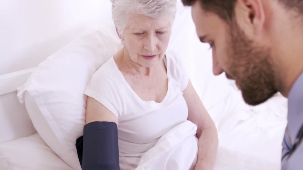 медсестра измеряет кровяное давление у пожилой женщины