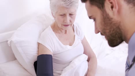 enfermero midiendo la presión arterial a una mujer mayor