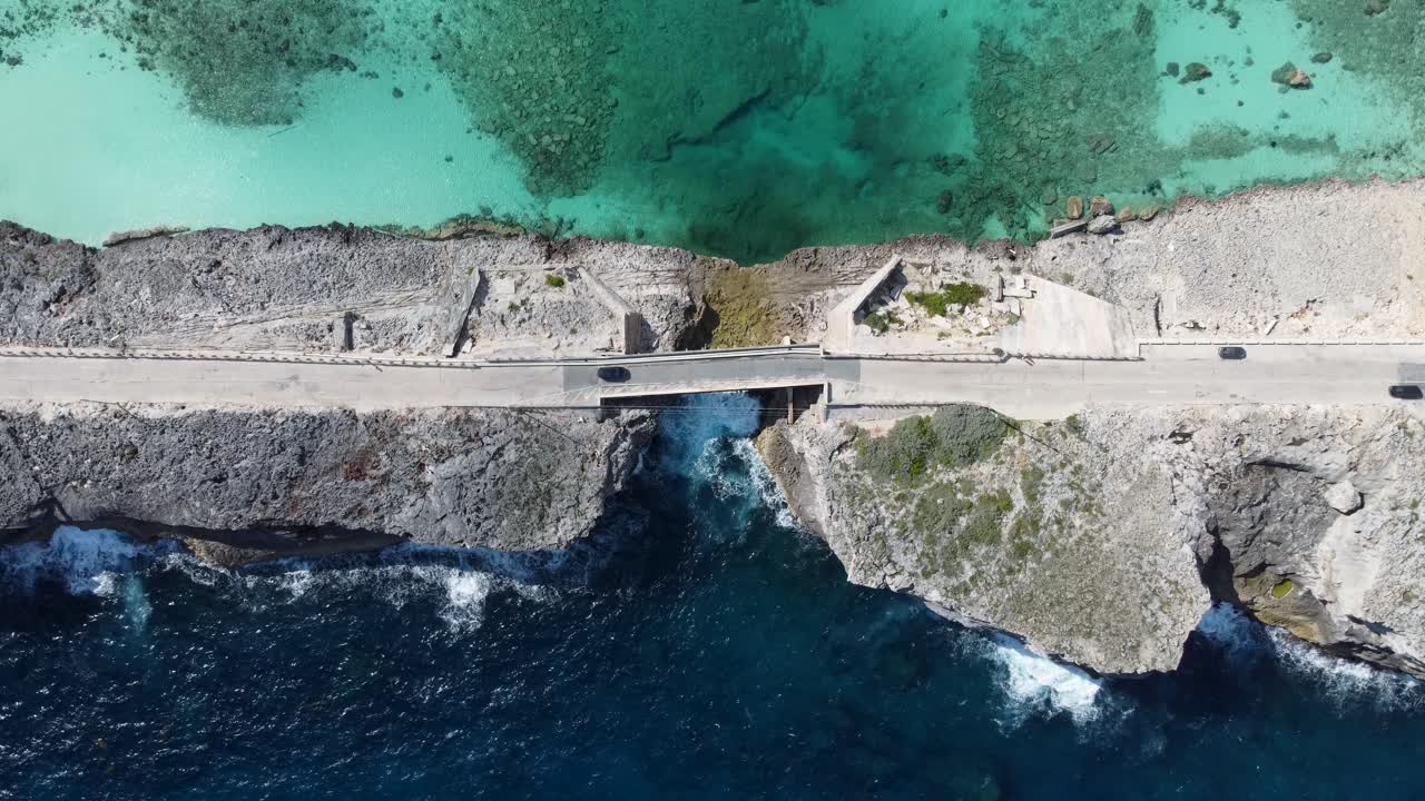 amplia vista aérea cinematográfica de arriba hacia abajo toma de drones del puente de la ventana de vidrio en la isla de eleuthera en las bahamas - separando el océano atlántico del mar caribe