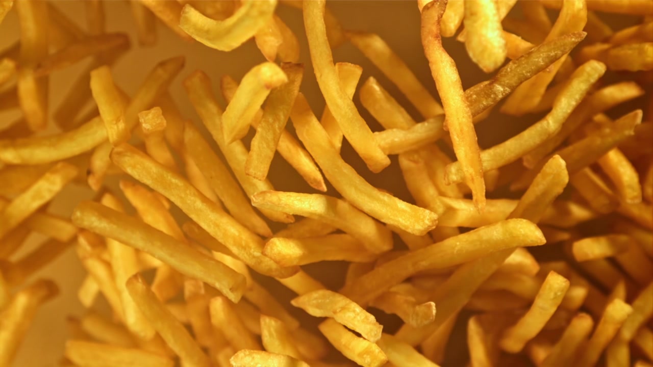 Patatas fritas doradas cayendo en cámara lenta
