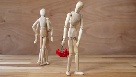 figurine with bunch of roses jealous with other couple on wooden background