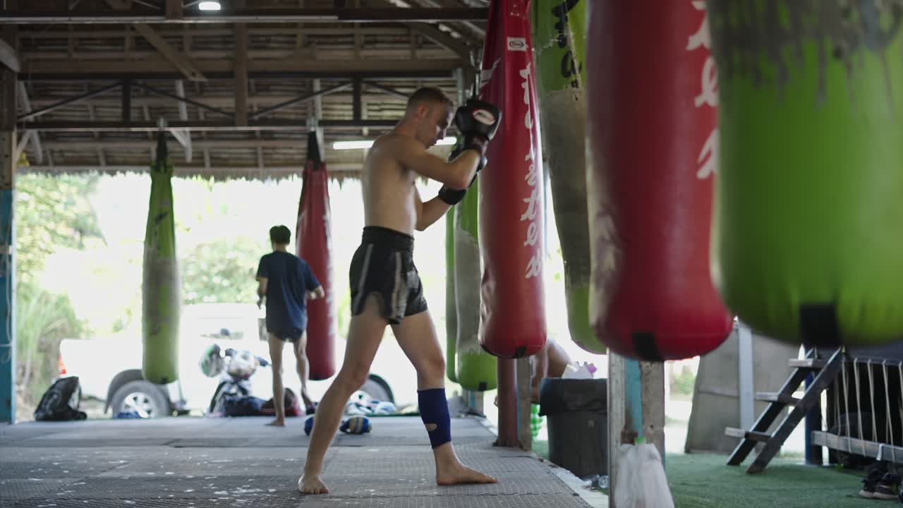 Man training Muay Thai in a gym