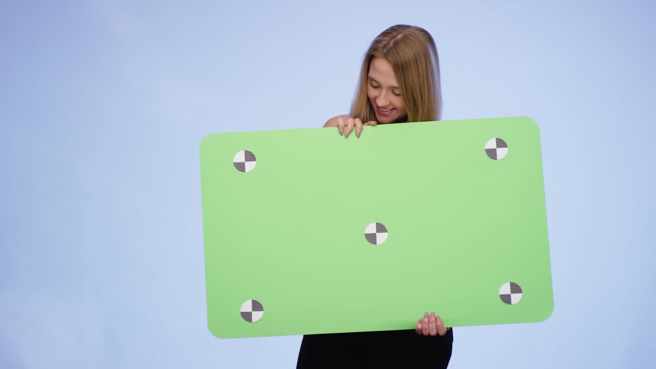 Cheerful Woman holding oversized blank Card on blue Background