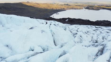 People-standing-on-ice-glacier-during-adventure-expedition,-aerial