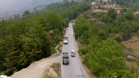 imágenes aéreas de automóviles y camiones conduciendo por una carretera montañosa al norte de huehuetenango en guatemala