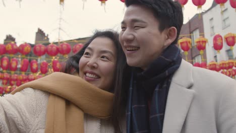차이나타운 런던 영국 2에서 휴대 전화에 셀카를 위해 포즈를 취하는 휴일에 젊은 아시아 부부