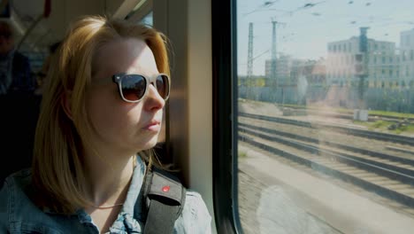 mujer con gafas de sol va en tren en verano