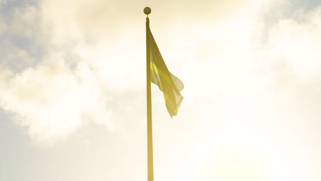 national flag of curacao, caribbean, raised atop a flag pole at sunset