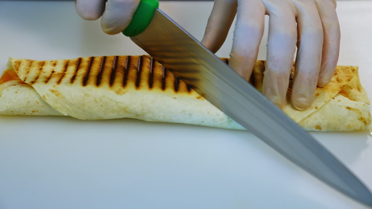 Shawarma rolled in lavash. Chef making chicken meat shawarma in professional restaurant kitchen
