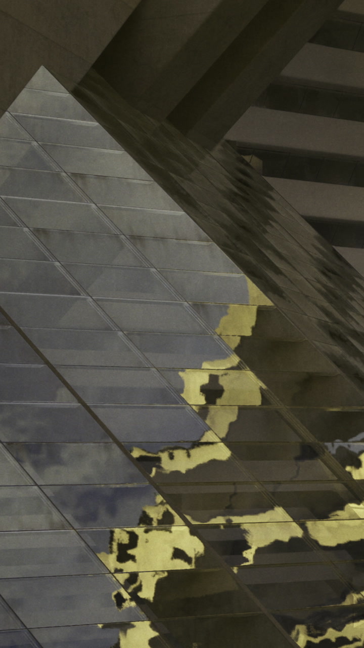 Building reflection on glass panels in an urban setting during the day
