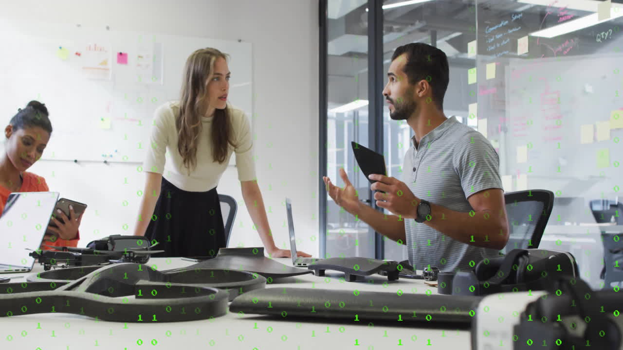 Diverse team discussing technology with binary code animation over office scene
