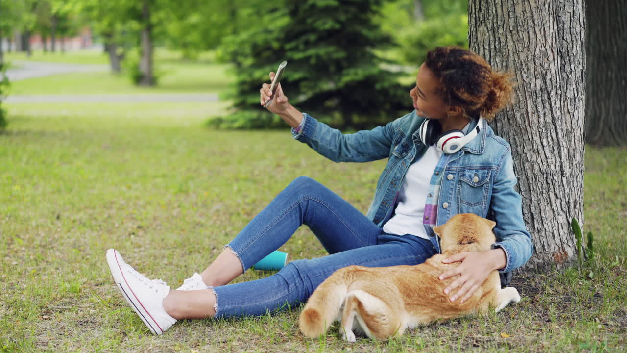 Ragazza adolescente che si fa un selfie con il suo cane in un parco