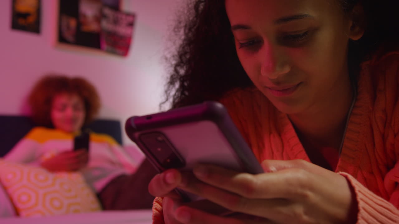 adolescentes usando teléfonos inteligentes en un dormitorio