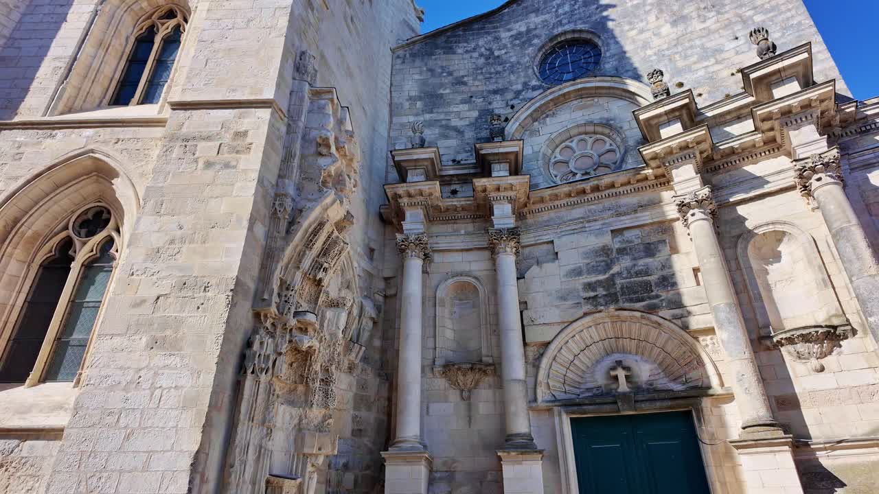 Saint-Sauveur Church, bell tower, and facade with blue sky in background, La Rochelle, France. Low-angle, tilt-up