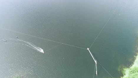 aerial drone shot of a water boarder being pulled through a bend