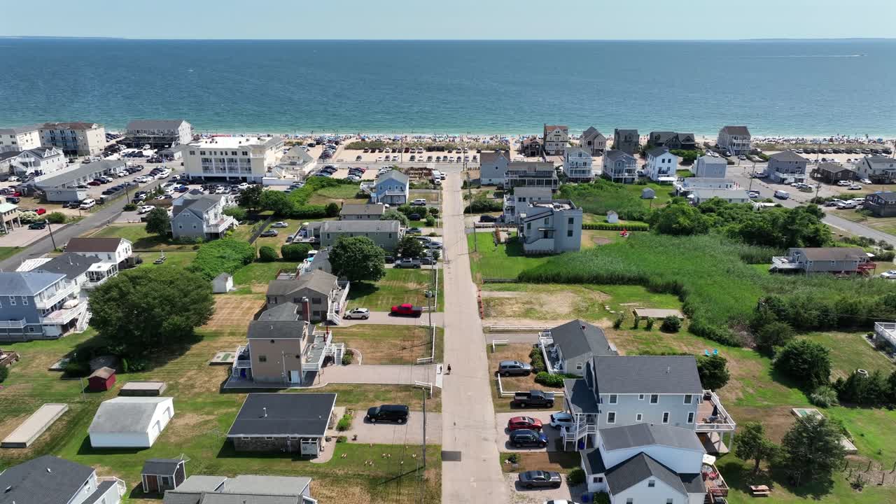 Aerial view of Misquamicut, Rhode Island, showing New England architecture with gabled roofs, clapboard siding and neatly aligned beach houses facing the Atlantic. Wide shot