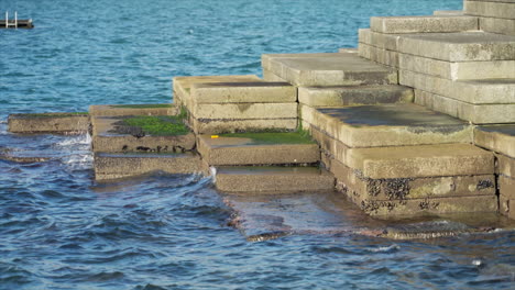 Waves-lapping-the-stone-slabs-in-Wellington,-New-Zealand