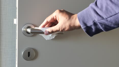 limpieza de una manija de la puerta con un pañuelo