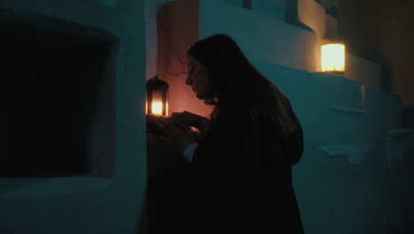 silhouette of mysterious woman reads holy book at night in a crypt