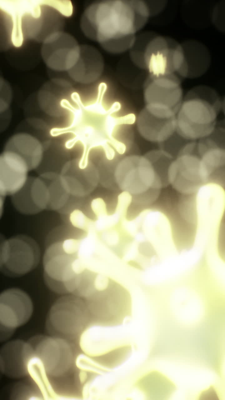 Floating micro organisms illuminate a dark background with a golden glow