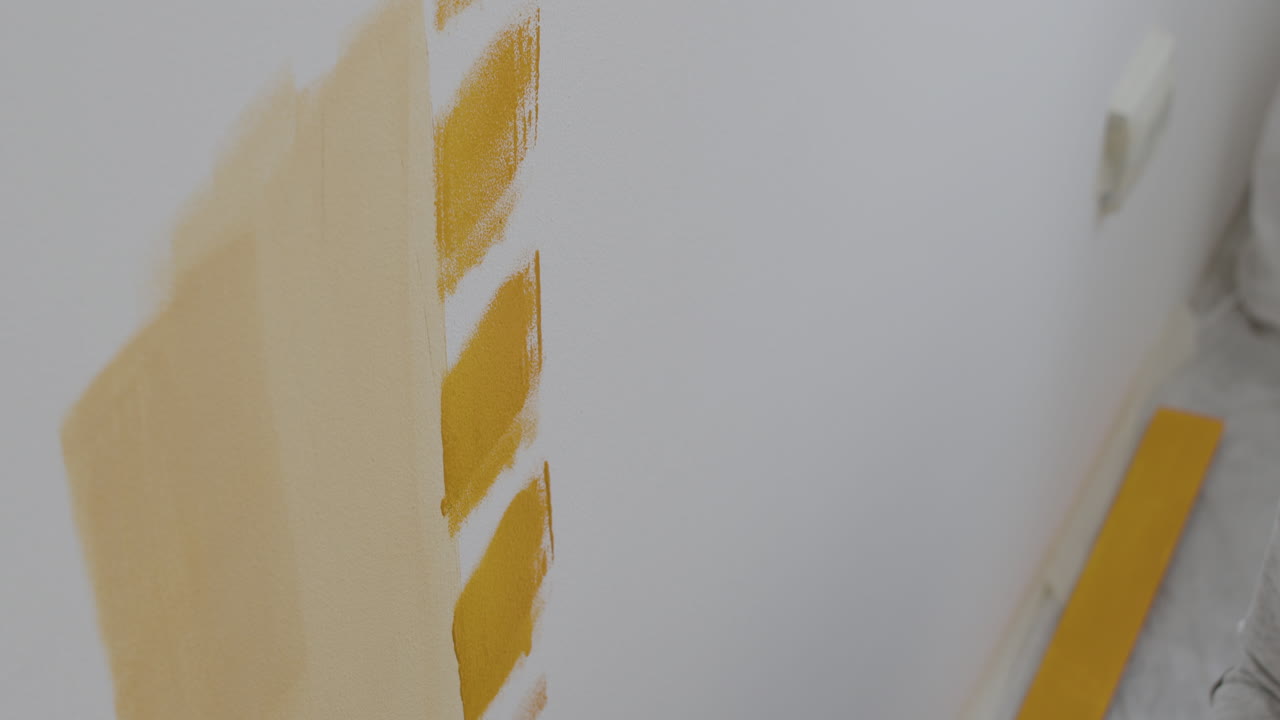Painting a wall yellow with a paint roller
