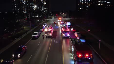 Vista-Aérea-De-Camiones-De-Bomberos-En-Una-Carretera-Por-La-Noche-Bloqueando-El-Tráfico-En-Toronto,-Ontario,-Canadá