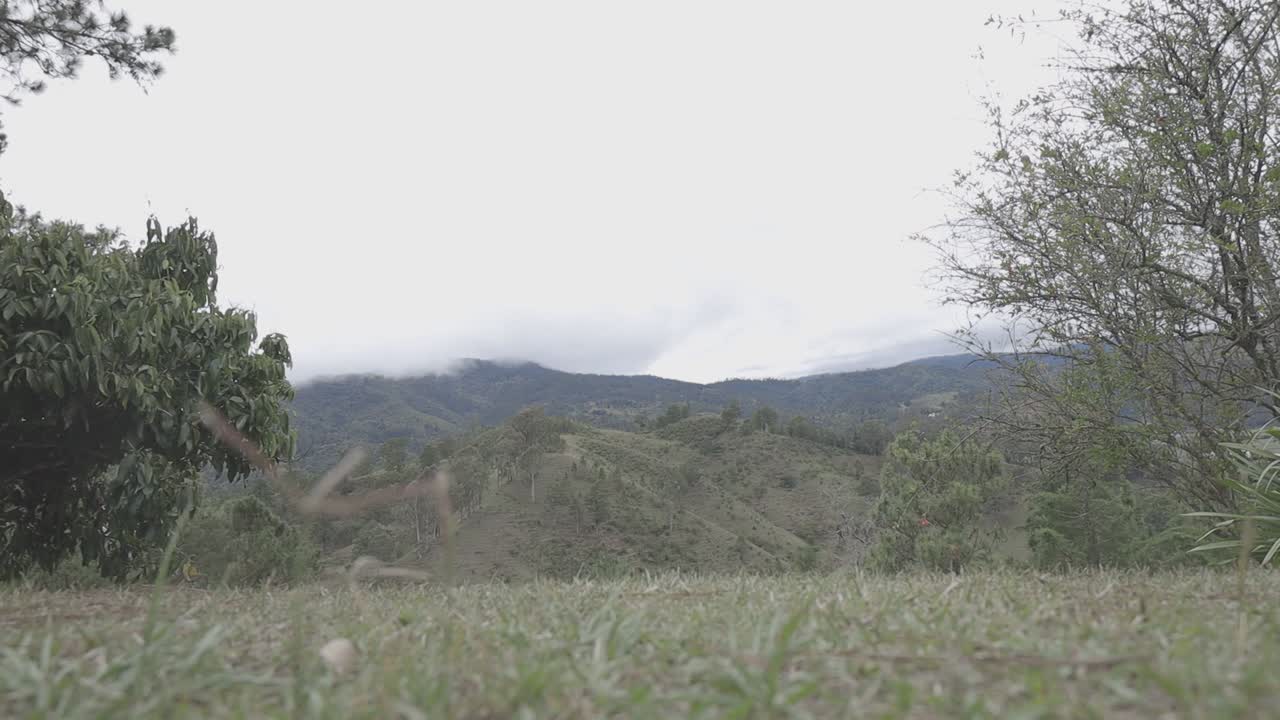 Pemandangan tenang dengan perbukitan bergelombang dan langit berawan