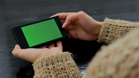 mujer usando un teléfono inteligente con pantalla verde
